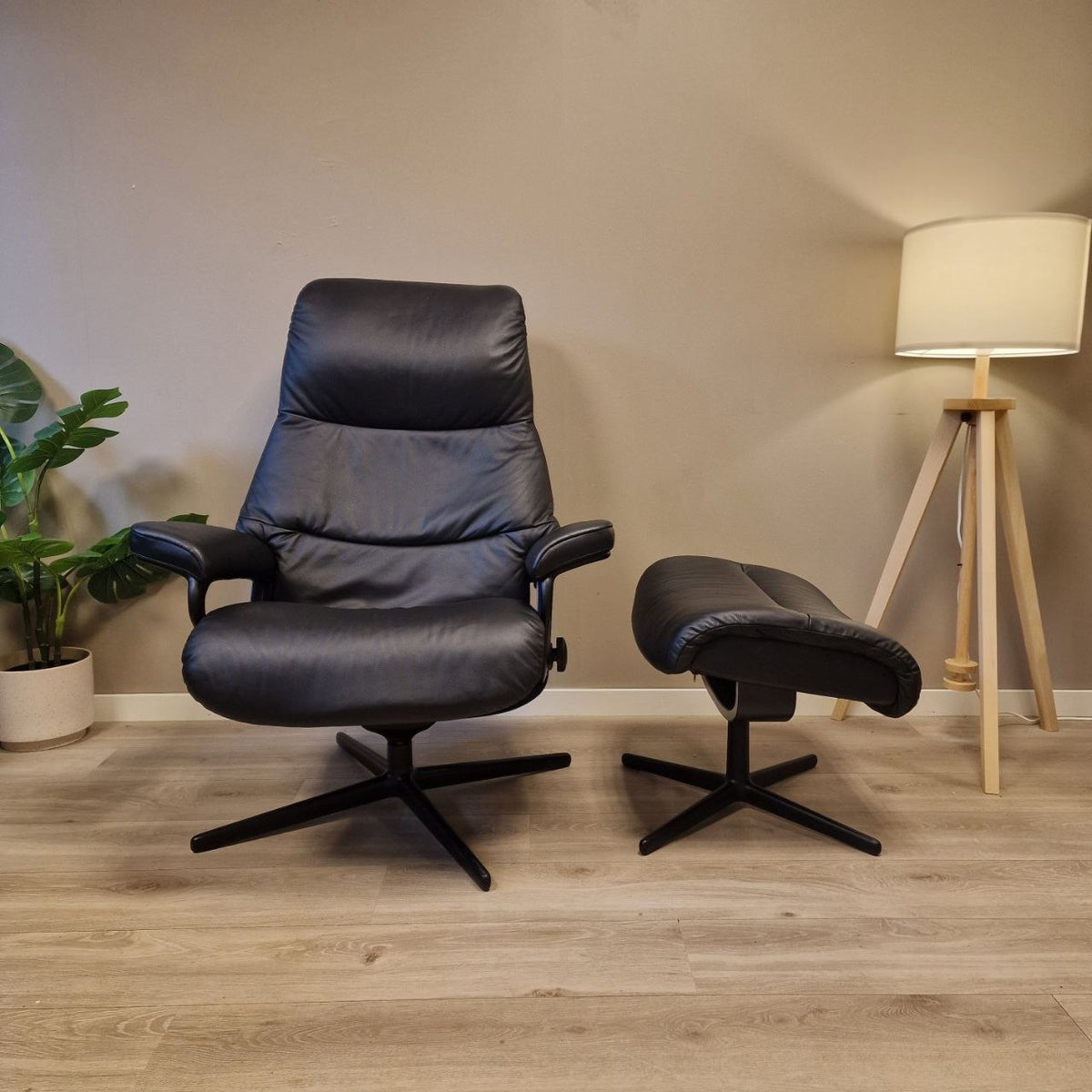 Stressless View (M) i svart skinn forfra med krakk ved siden av