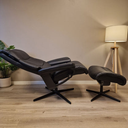 Stressless View lenestol i svart skinn i helt tilbakelent hvilestilling, med krakk